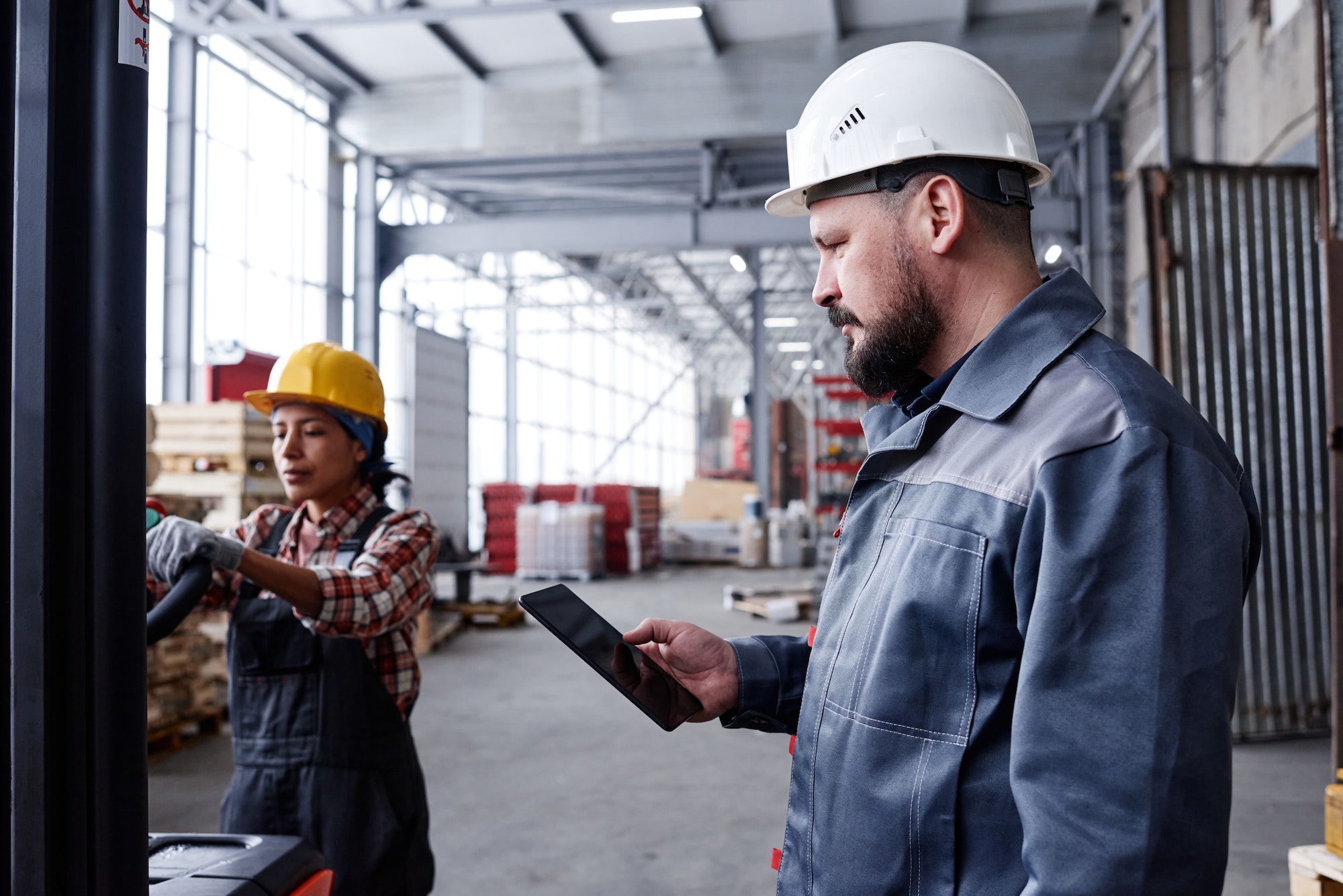 Bearded foreman or picker with tablet checking online orders in warehouse