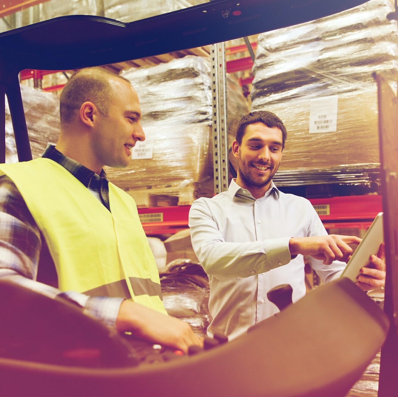 happy men with tablet pc and forklift at warehouse