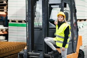 Woman forklift truck driver in an industrial area.